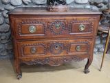 une commode en bois surmontée d'une statue