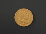 a close up of a gold coin on a black surface