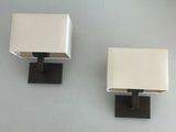 pair of white and black lamps on a white wall