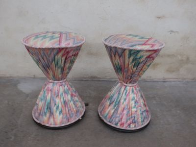 two vases that are sitting on a concrete floor