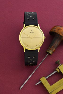 une montre posée sur une table à côté d'une paire d'outils