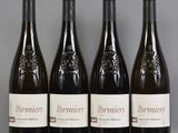 four bottles of wine are lined up on a table