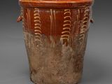 a brown vase that has a design on it