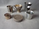 several silver cups and cups are sitting on a table