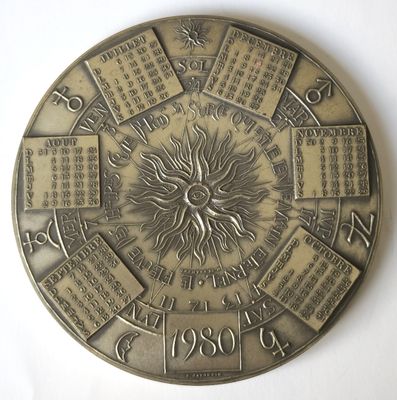 une horloge ornée d'un soleil, posée sur une surface blanche