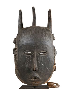 une image représentant un masque en bois muni de cornes sur fond blanc