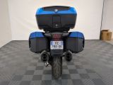 a picture of a blue motorcycle parked on a checkered floor