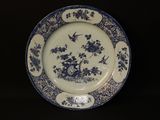 a blue and white plate with birds and flowers on it