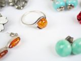 a lot of different rings and earrings on a table