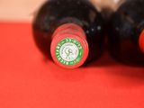 two bottles of wine sitting on a red table