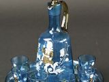une carafe en verre bleu et or posée sur un plateau