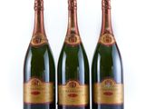 three bottles of champagne sitting on top of a white surface