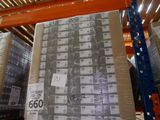 une grande pile de cartons dans un entrepôt, sur laquelle est apposée une étiquette de prix