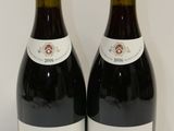 deux bouteilles de vin rouge posées l'une à côté de l'autre sur une table