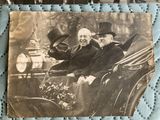 two men riding in a horse drawn carriage together