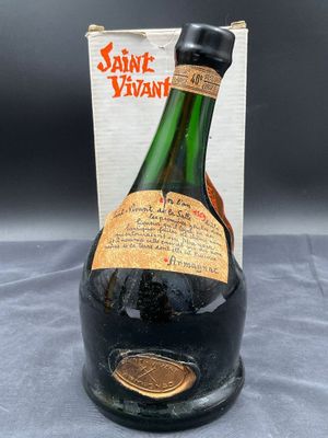 une vieille bouteille de vin posée sur une table, à côté d'une boîte