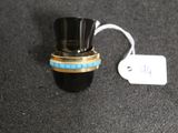 a small black bottle with a gold ring on top of it
