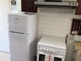a small kitchen with a refrigerator, stove, and refrigerator freezer