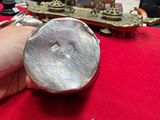 a person holding a silver object on a red table