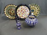 a lot of different plates and vases on the table