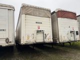 trois semi-remorques garées côte à côte dans un champ