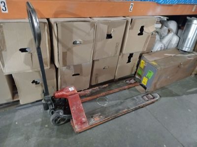 a fork lifter that is sitting in front of a bunch of boxes