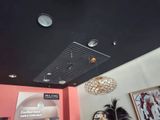 une femme qui se tient debout dans une pièce où il y a une horloge au plafond