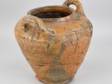 a brown vase with a handle on a white surface