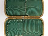 a green case that has a pair of scissors inside of it