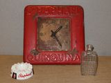 une horloge rouge posée sur une table, à côté d'une tasse de café