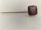 an image of a piece of gold and amethorate on a stick