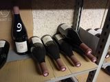 several bottles of wine are lined up on a shelf in a wine shop