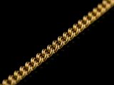 close up of a gold chain on a black background