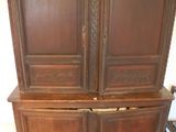 une grande armoire en bois sur laquelle sont posées de nombreuses assiettes