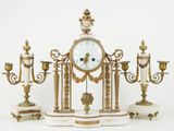 an image of a clock with candles and a candle holder on a white surface