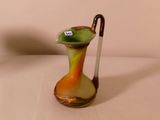 un vase vert et jaune dans lequel se trouve un bâton