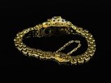 a close up of a gold bracelet on a black background