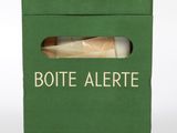 green box with a piece of bread inside of it on a white surface