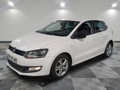 the white volkswagen polo is parked on a checkered tile floor