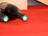 three bottles of wine sitting on a red table