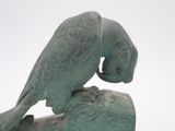 a statue of a bird sitting on top of a rock