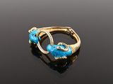 an image of a gold and turquoise ring on a black surface
