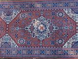 an image of a red and blue oriental rug on display
