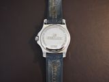 a close up of a watch on a brown surface
