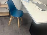 a white desk with a blue chair and a laptop on it