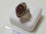 une bague en argent surmontée d'une pierre rouge