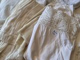 a pile of clothing on a bed with a white comforter