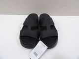 the pair of black sandals are sitting on a white surface