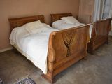 two beds in this bedroom with a wooden sleigh