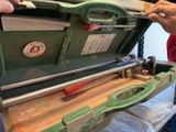 un homme qui tient un outil dans un coffret vert